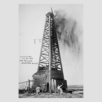 An oil tower with smoke coming out the top